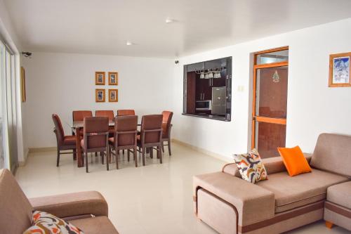 ein Wohnzimmer mit einem Sofa, einem Tisch und Stühlen in der Unterkunft CASA TALIOS in Carhuaz