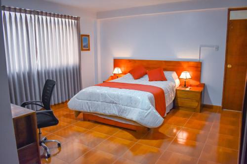 um quarto com uma cama, uma secretária e uma televisão em CASA TALIOS em Carhuaz