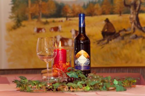 a bottle of wine and a candle on a table at Rehwinkel in Bodenmais