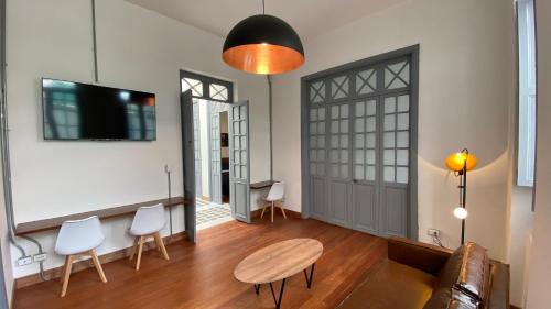 a living room with a table and chairs and a tv at REPUBLICANA CASA HOSTAL - HABITACIÓN 6 CALIMA in Bogotá