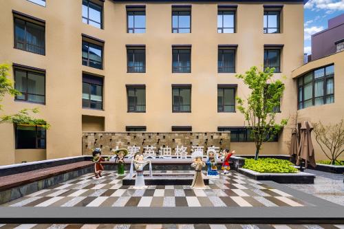 a rendering of a building with figurines in front of it at Hotel Indigo Jiuzhai by IHG in Jiuzhaigou