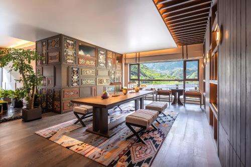 a dining room with a table and chairs and a large window at Hotel Indigo Jiuzhai by IHG in Jiuzhaigou