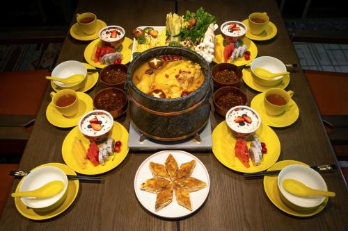 a table full of food on a wooden table at Hotel Indigo Jiuzhai by IHG in Jiuzhaigou