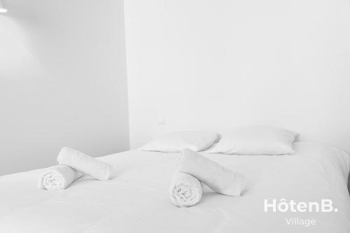 - un lit blanc avec des oreillers et des serviettes blancs dans l'établissement T3 Duplex charme de l'ancien - coeur de ville, à Limoges