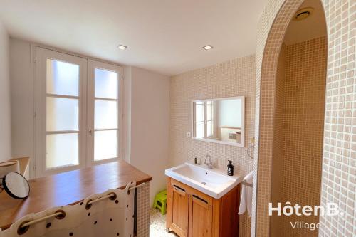 une salle de bain avec un lavabo et un miroir dans l'établissement T3 Duplex charme de l'ancien - coeur de ville, à Limoges