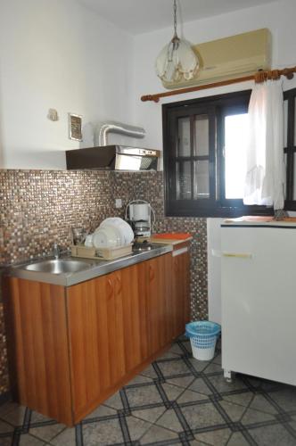 a kitchen with a sink and a counter top at Giannis Maria Apartments in Psakoudia