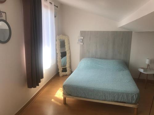 Dormitorio pequeño con cama y espejo en Charmant 3 pièces 3 eme etage, en Sospel