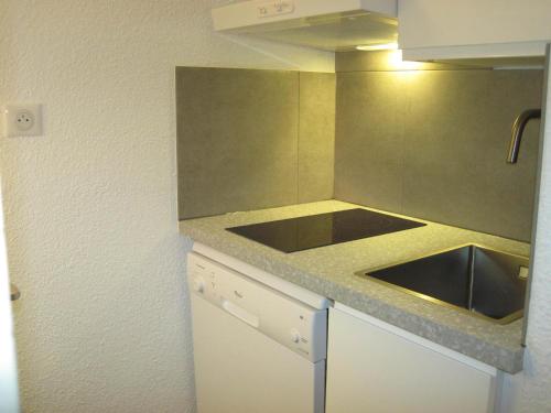 une petite cuisine avec un évier et un comptoir dans l'établissement Studio confortable au cœur de la station, proche pistes et commerces - FR-1-181-2538, à La Plagne Tarentaise