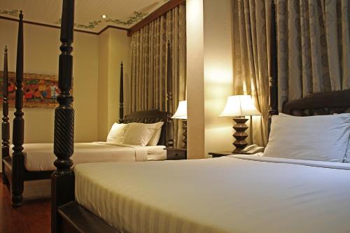 a hotel room with two beds and a lamp at Hotel Veneto De Vigan in Vigan