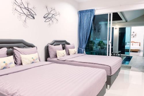 1 dormitorio con 2 camas y sofá en Be19th Pool Villa, en Cha Am