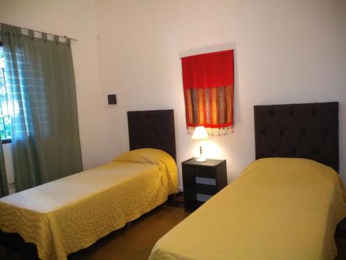 una stanza con due letti e un dipinto sul muro di LF Departamentos a Córdoba