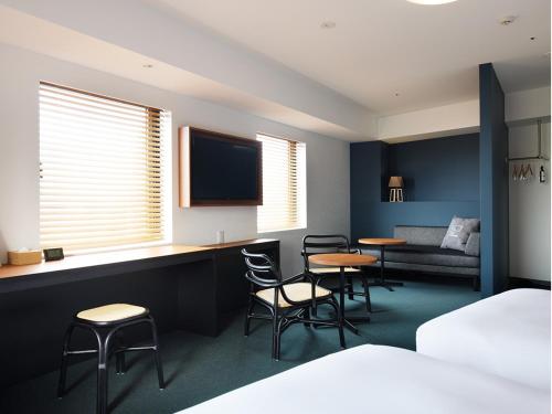 a hotel room with a bed and two tables and chairs at hotel androoms Naha Port in Naha