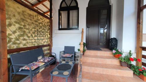 a porch with two blue benches and a door at Cazare la fermă in Galeşu