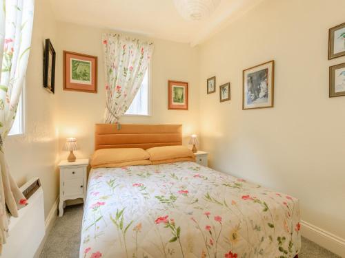 a bedroom with a bed and two windows at Clooneavin Chalet in Lynmouth