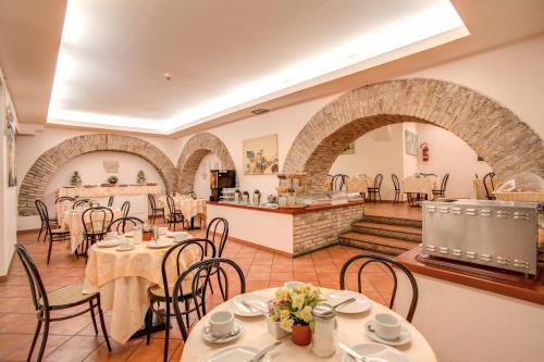 um restaurante com mesas e cadeiras num quarto em Hotel Corona em Roma