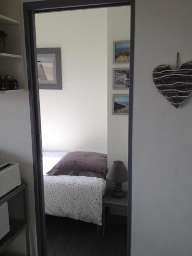 un miroir reflétant une chambre avec un lit dans l'établissement La Croix du Sud, à Le Touquet-Paris-Plage