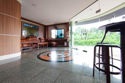 a living room with a bar stool and a couch at Perfectroom Mansion in Hat Yai