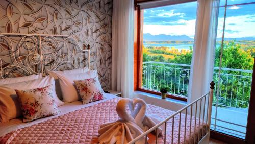 a bedroom with a bed with a large window at The Elysian at Nicopolis jacuzzi in Nikópolis