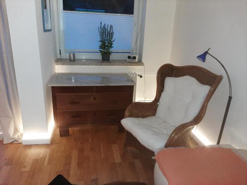 Una sala de estar con una silla y una ventana. en Weitblick, en Bad Harzburg