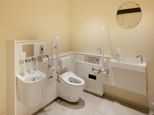 a bathroom with a toilet and a sink and a mirror at hotel androoms Naha Port in Naha