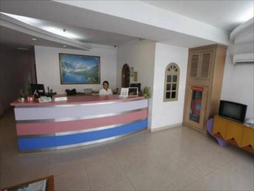 a woman sitting at a counter in a lobby at Century Hotel Inanam in Kota Kinabalu