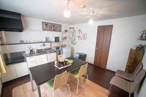 a kitchen with a table and chairs in a room at Tomoeドットコム2 onepiecehouse in Hakodate