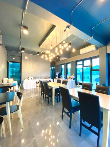 a dining room with tables and chairs and windows at ABIZZ Hotel KwanPhayao in Phayao