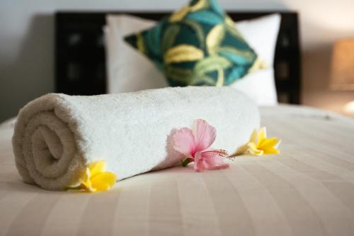 a roll of toilet paper on a bed with flowers at Manta Dive Gili Trawangan Resort in Gili Trawangan
