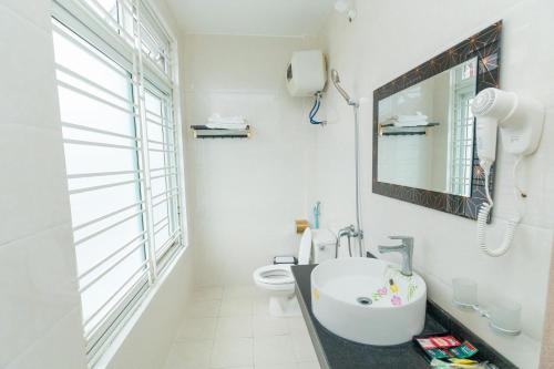 a bathroom with a sink and a toilet at Nhà nghỉ Đức Trọng in Móng Cái