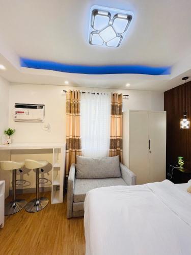 a hotel room with a bed and a couch and a table at Lou- Mesaverte Residences in Cagayan de Oro