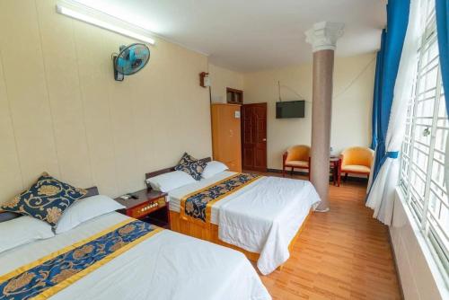 Habitación de hotel con 2 camas y ventana en Nhà nghỉ Đức Trọng en Móng Cái