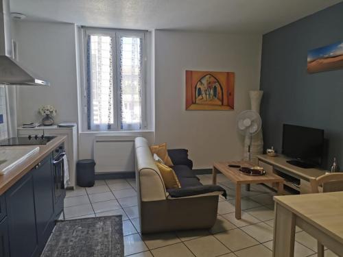 salon z kanapą i stołem w obiekcie Joli appartement climatisé w mieście Périgueux