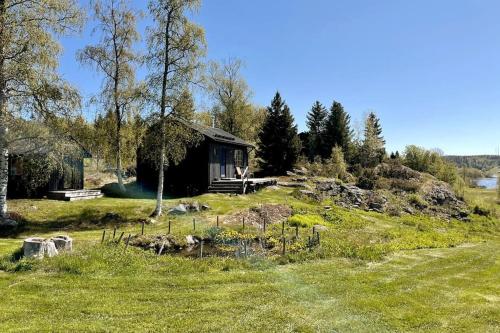 una pequeña cabaña en una colina en un campo en Tynderösundet - Gråstugan 