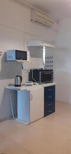 an office with a counter with a microwave and a computer at Alex Central City Accommodation in Lávrion