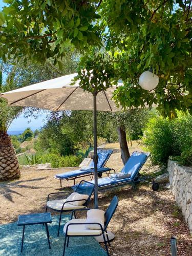 a group of chairs and an umbrella with chairs and tables at Villa in Gargano - VILLA BASSO in Monte SantʼAngelo