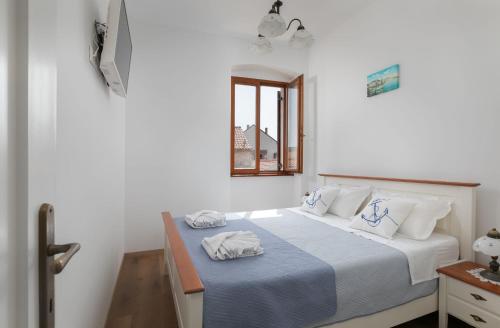 ein Schlafzimmer mit einem Bett mit zwei Handtüchern darauf in der Unterkunft Ancora Faros in Stari Grad