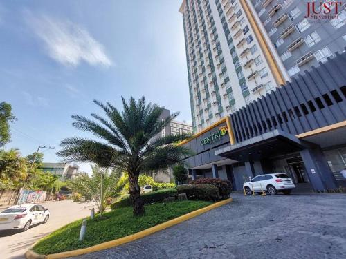 a palm tree in front of a building at King Size Bed At the Heart Of the City in Cagayan de Oro