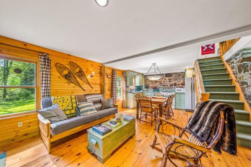 a living room with a couch and a staircase at Brook Sound Cabin in Schroon Lake