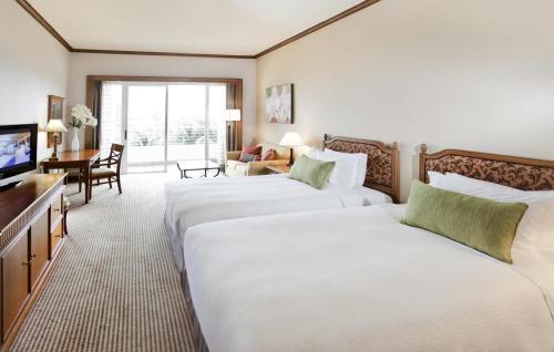 Postel nebo postele na pokoji v ubytování Dorsett Grand Labuan