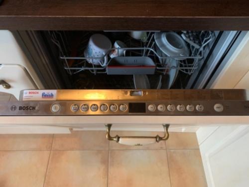 an open dishwasher with a bunch of dishes in it at Chalupa na Leskové in Velké Karlovice