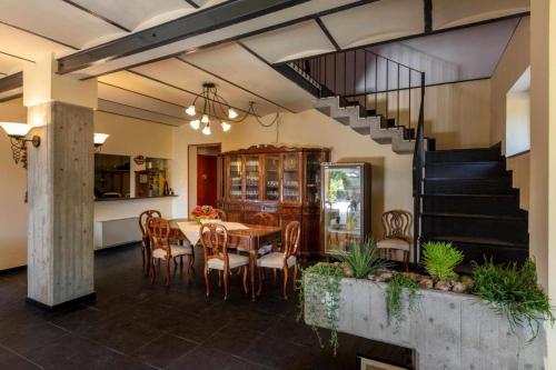 a dining room with a table and chairs and a staircase at La Meriggia Senigallia Agriturismo in Ancona