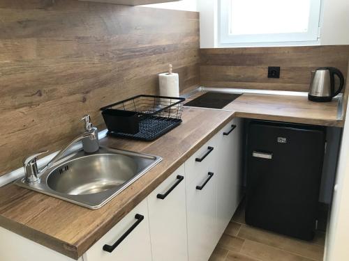 a small kitchen with a sink and a refrigerator at Вила TIMeS in Kiten