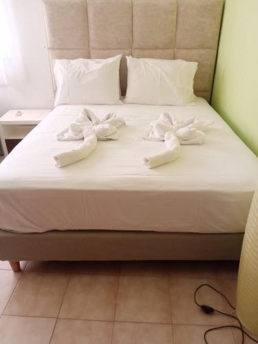 a bed with white slippers on top of it at 360 Panorama House - Gazing at Horizon and the Stars of the Galaxy in the night - Fresh Cool breeze most of the time - just 7 min from the beach in Kournás