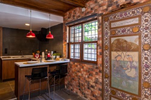 Nills Suite Villa في أنطاليا: مطبخ مع جدار من الطوب وبار مع الكراسي