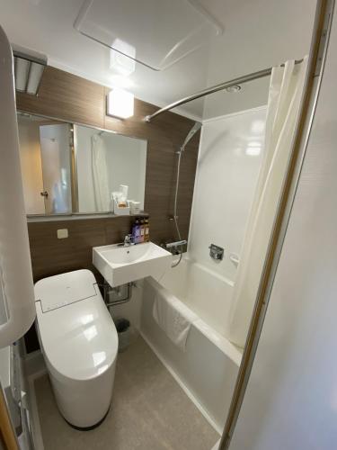 a bathroom with a toilet and a sink and a shower at Hotel St Palace Kurayoshi in Kurayoshi