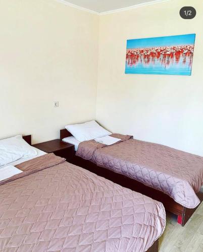 a room with two beds and a painting on the wall at Буджак / Budjak in Primorskoye