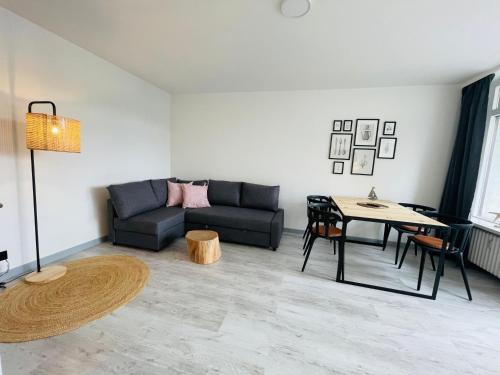 a living room with a couch and a table at Apartment Sünnanbeter mit Pool für 2-4 Personen in Dahme