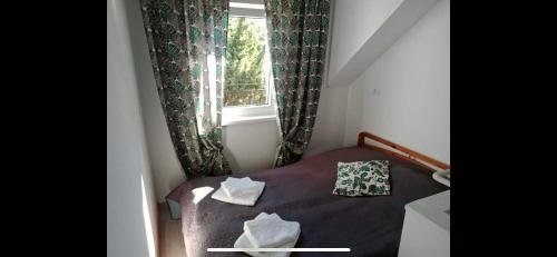 a small bed in a small room with a window at Krab in Rewal