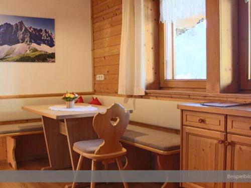 a kitchen with a table and a chair and a window at Apartment at the Achensee in Achensee