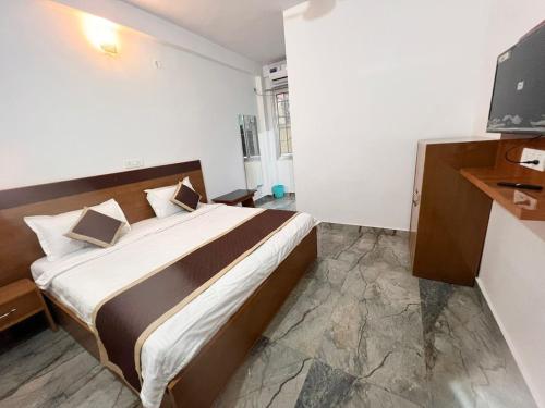 a hotel room with a bed and a television at Hotel Manikut in Rishīkesh